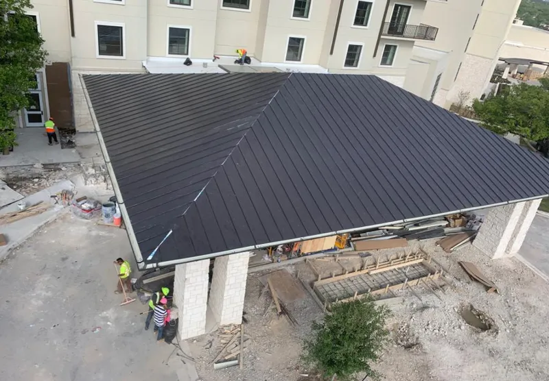 Metal roofing installation team working on a commercial building in Logan